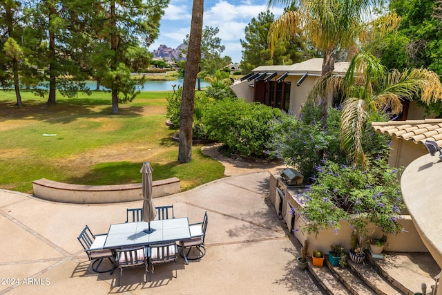 surrounding community with a yard, a patio, and a water view