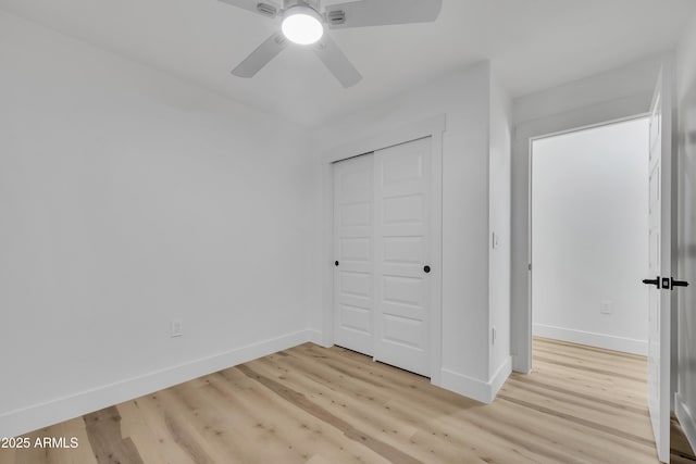 unfurnished bedroom with ceiling fan, a closet, baseboards, and light wood-style flooring