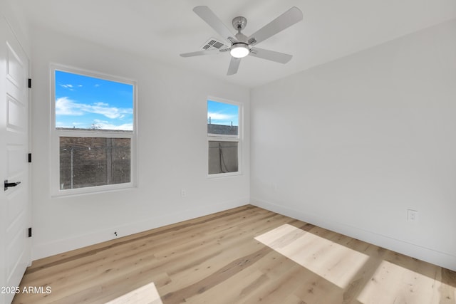 spare room with visible vents, light wood-style flooring, baseboards, and ceiling fan