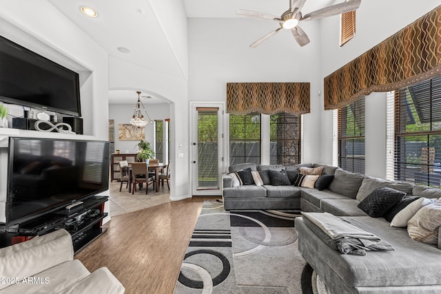9285 E Canyon Vw, Scottsdale, AZ 85255 - living area featuring ceiling fan with notable chandelier, a high ceiling, wood finished floors, and arched walkways