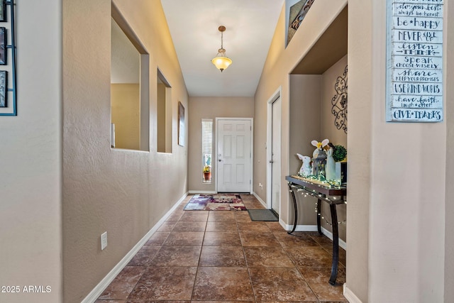 doorway with stone finish flooring and baseboards