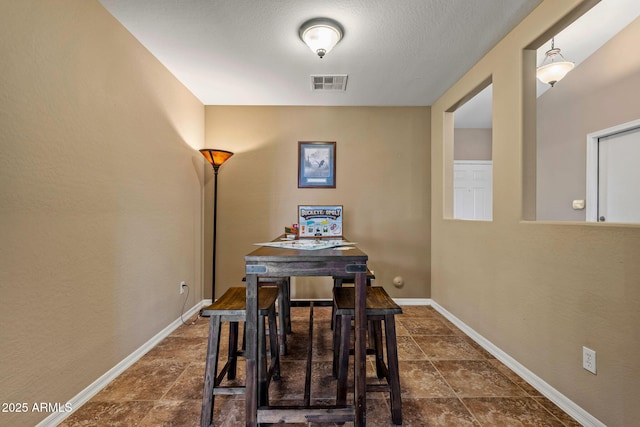 dining room featuring visible vents, baseboards, and stone finish flooring