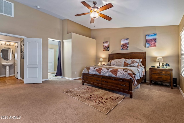 bedroom featuring baseboards, visible vents, carpet floors, a sink, and ensuite bathroom