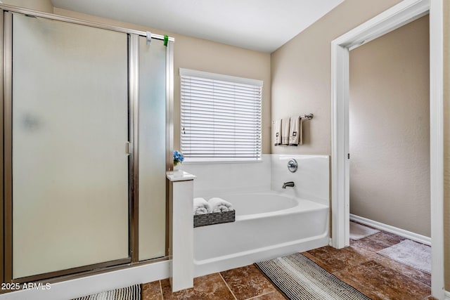 full bath featuring a stall shower, baseboards, and a garden tub