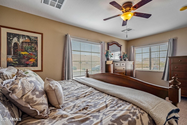 carpeted bedroom with visible vents and ceiling fan