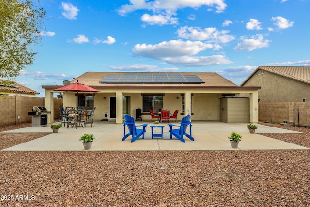 back of house featuring outdoor dining space, a patio, a fenced backyard, and stucco siding