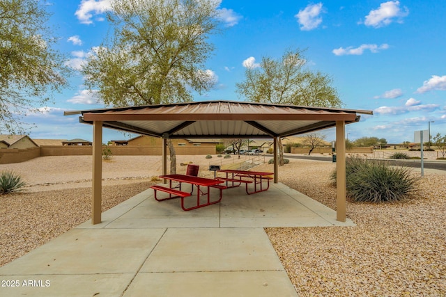 view of property's community featuring a patio area, a gazebo, and fence