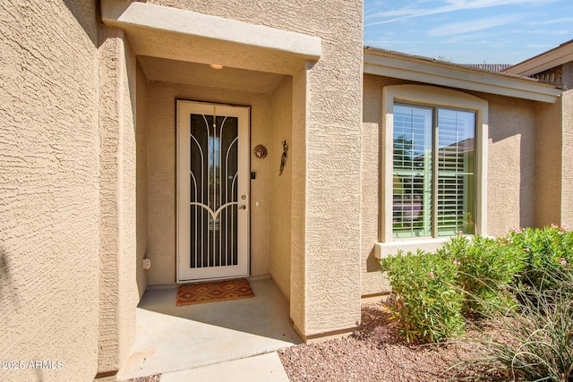 entrance to property featuring stucco siding