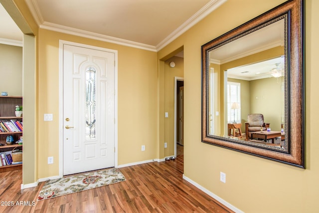 entrance foyer featuring wood finished floors, baseboards, and ornamental molding