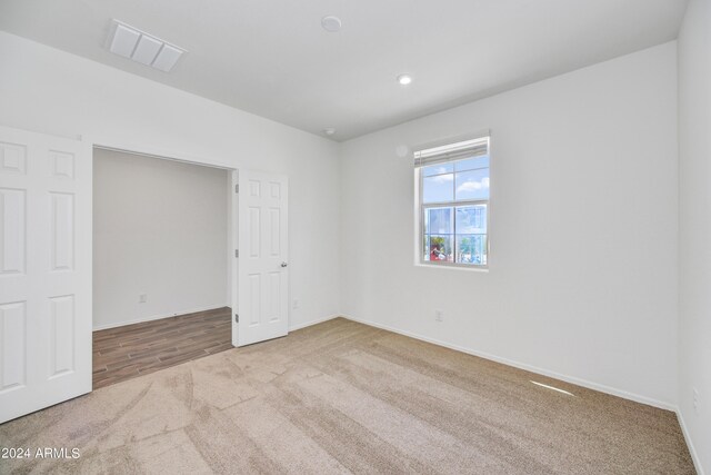 empty room featuring recessed lighting, carpet flooring, baseboards, and visible vents