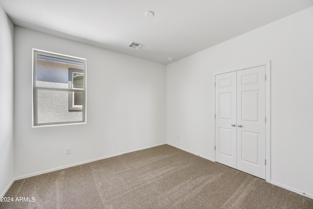 carpeted spare room with baseboards and visible vents