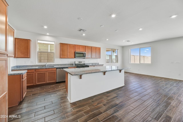 kitchen featuring a sink, appliances with stainless steel finishes, a breakfast bar, visible vents, and a kitchen island