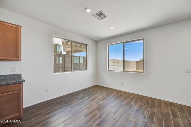 spare room featuring baseboards, visible vents, dark wood-type flooring, and recessed lighting