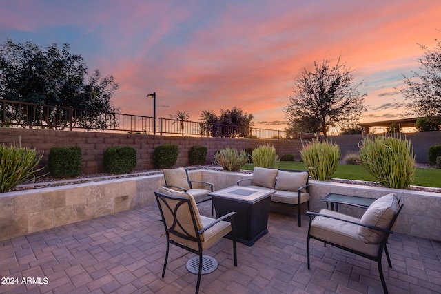 patio terrace at dusk featuring an outdoor living space with a fire pit