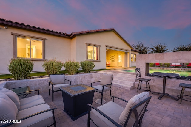 patio terrace at dusk featuring an outdoor living space