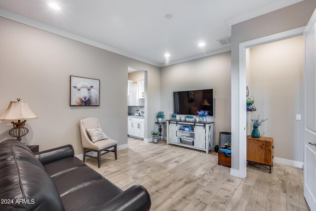 living room featuring light hardwood / wood-style flooring and crown molding