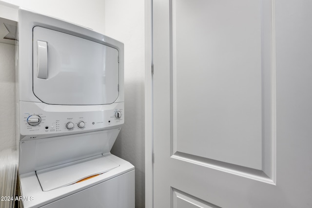 clothes washing area featuring stacked washing maching and dryer