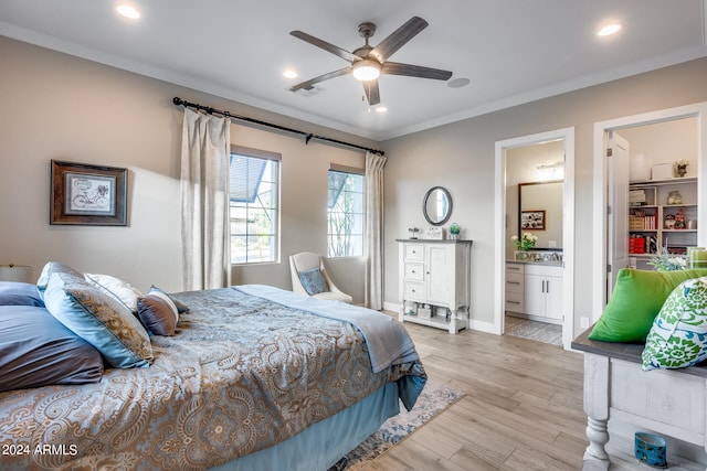 bedroom featuring ceiling fan, ornamental molding, connected bathroom, and light hardwood / wood-style floors