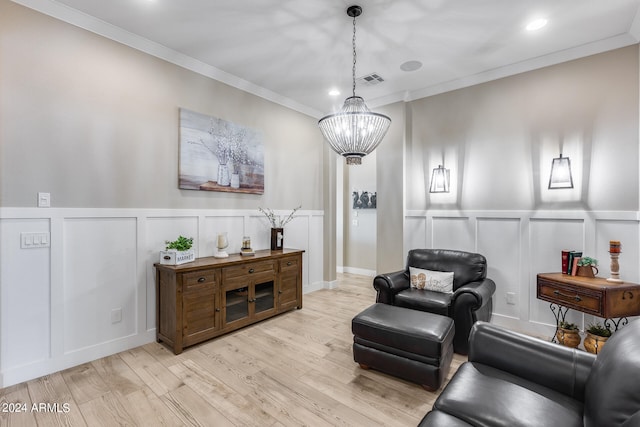 sitting room featuring crown molding, light hardwood / wood-style flooring, and a chandelier