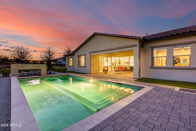 pool at dusk with a patio