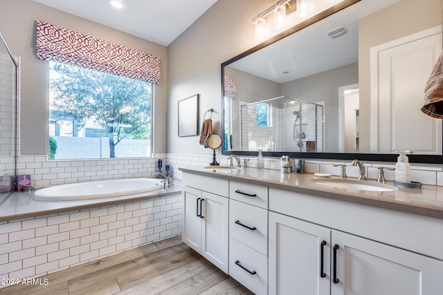 bathroom featuring hardwood / wood-style floors, vanity, and separate shower and tub