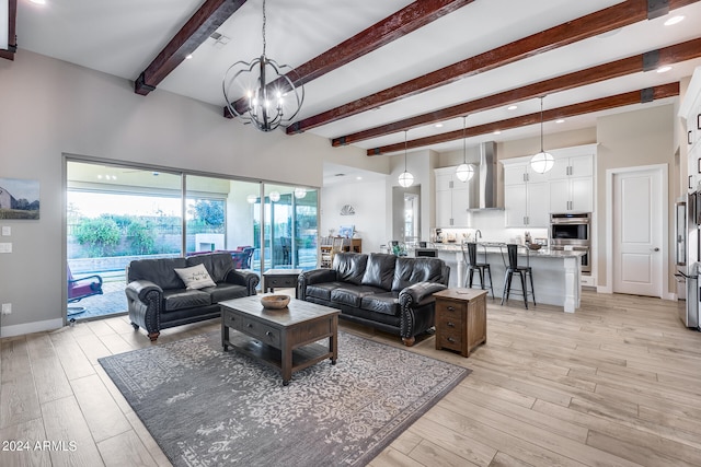 living room with beamed ceiling, an inviting chandelier, and light hardwood / wood-style flooring