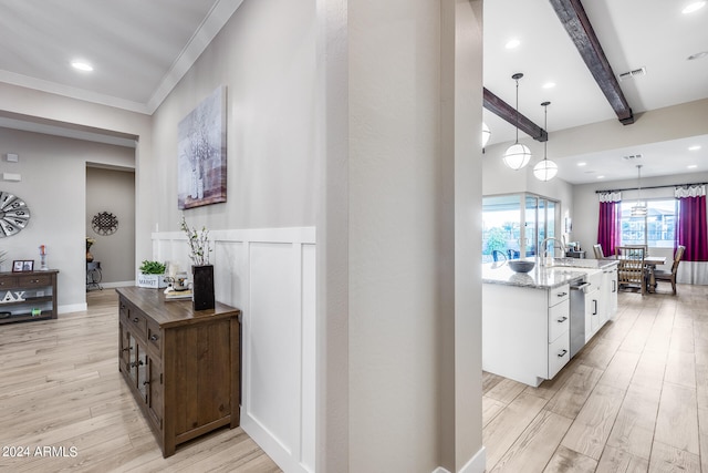 hallway with ornamental molding, sink, light wood-type flooring, and beam ceiling