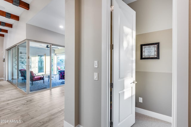 corridor featuring light hardwood / wood-style floors and beam ceiling