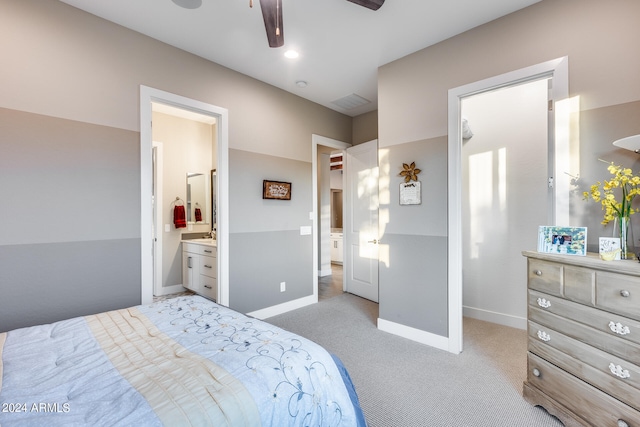 carpeted bedroom with ensuite bath and ceiling fan