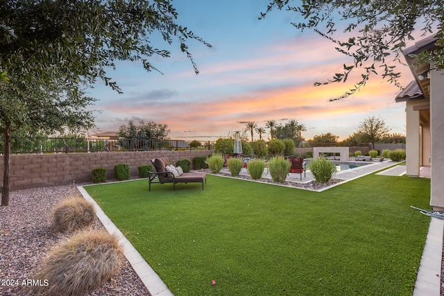 yard at dusk featuring a patio, an outdoor fire pit, and a fenced in pool