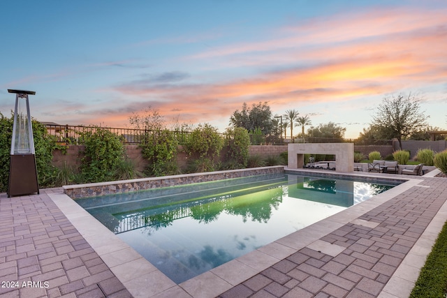 pool at dusk with a patio