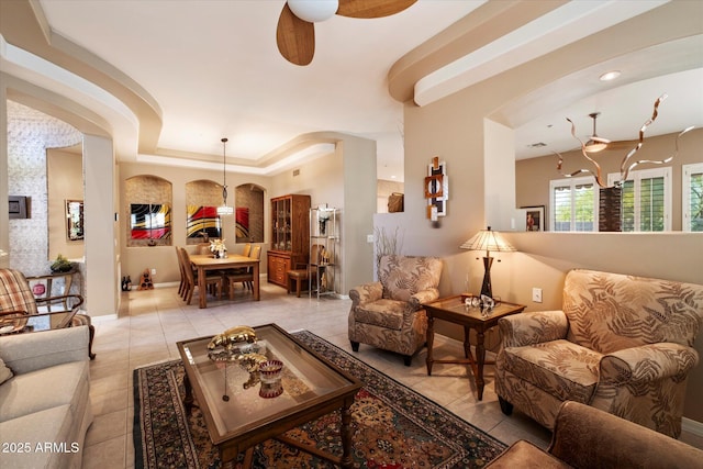 7291 E Eagle Feather Rd, Scottsdale, AZ 85266 - living room with tile patterned floors, a ceiling fan, arched walkways, a tray ceiling, and baseboards