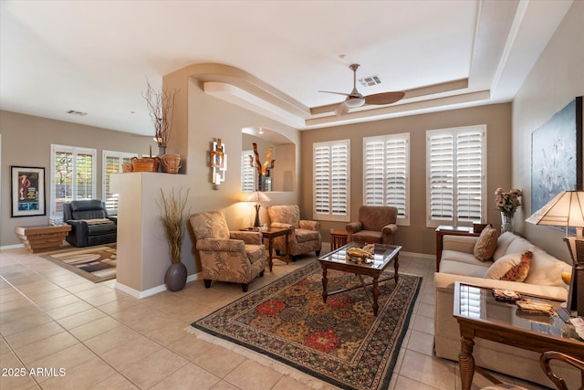 7291 E Eagle Feather Rd, Scottsdale, AZ 85266 - living area with ceiling fan, a tray ceiling, light tile patterned floors, and baseboards