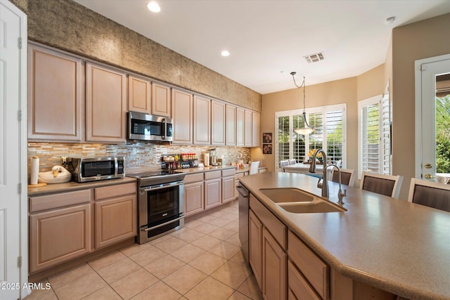 7291 E Eagle Feather Rd, Scottsdale, AZ 85266 - kitchen featuring appliances with stainless steel finishes, a sink, decorative backsplash, light tile patterned floors, and healthy amount of natural light