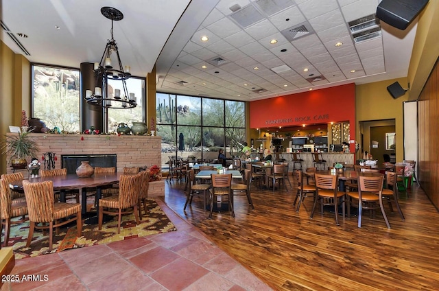 7291 E Eagle Feather Rd, Scottsdale, AZ 85266 - dining space with floor to ceiling windows, a high ceiling, a fireplace, a chandelier, and recessed lighting