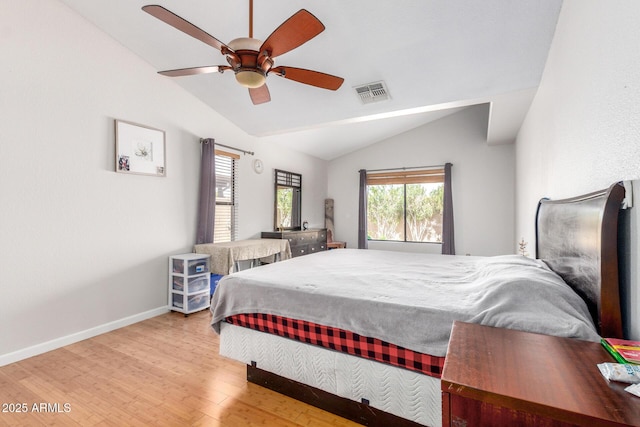 bedroom featuring wood finished floors, a ceiling fan, visible vents, vaulted ceiling, and baseboards