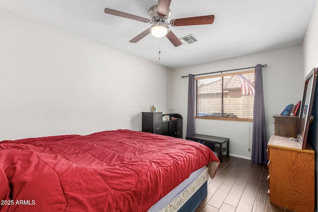 bedroom with baseboards, visible vents, ceiling fan, and wood finished floors