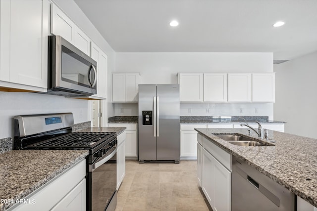 kitchen featuring sink, light stone counters, white cabinetry, and appliances with stainless steel finishes