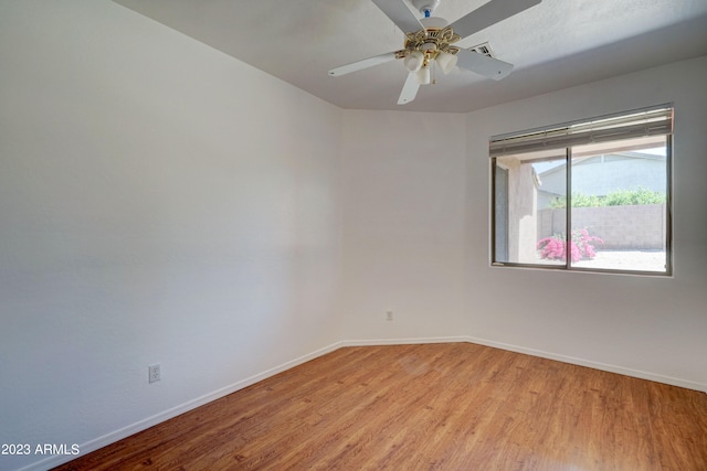 empty room with ceiling fan and light hardwood / wood-style flooring