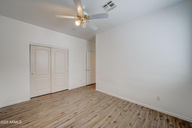 unfurnished bedroom featuring light hardwood / wood-style floors, a closet, and ceiling fan