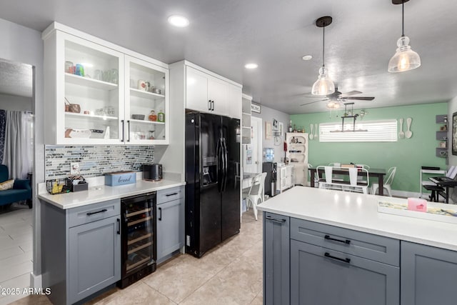 kitchen featuring wine cooler, black refrigerator with ice dispenser, and gray cabinetry