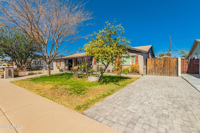 single story home with a front yard, a gate, and fence