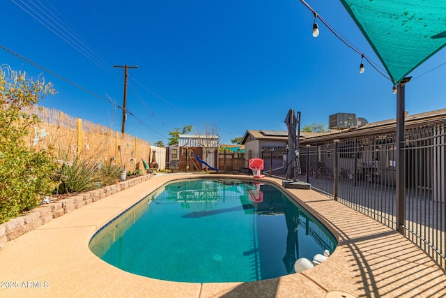 view of pool with a fenced backyard, a fenced in pool, and a playground