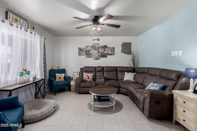 living area with light tile patterned floors and a ceiling fan