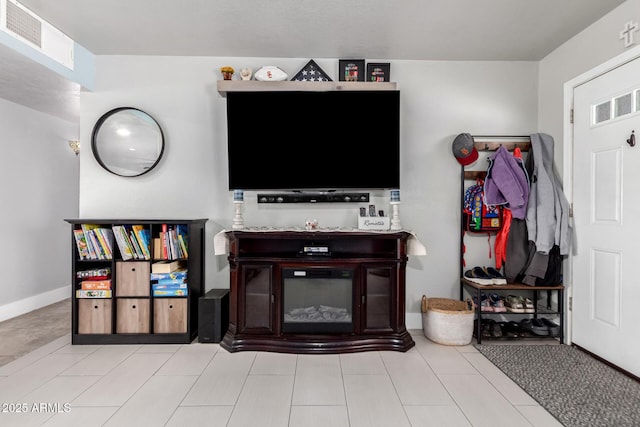 living room with tile patterned floors, visible vents, and baseboards