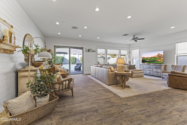 living area featuring recessed lighting, visible vents, and wood finished floors