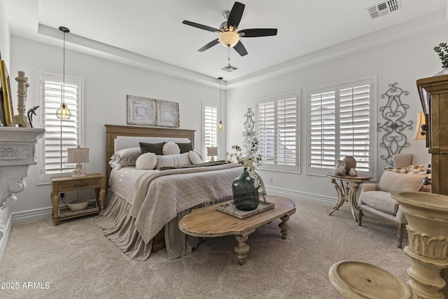 bedroom with visible vents, a raised ceiling, and carpet floors