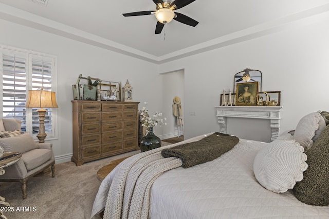 bedroom featuring ceiling fan, a raised ceiling, baseboards, and carpet floors