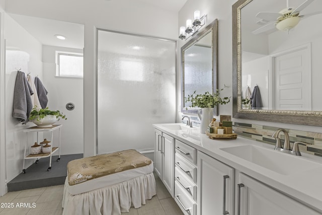 bathroom with a sink, tasteful backsplash, ceiling fan, and double vanity