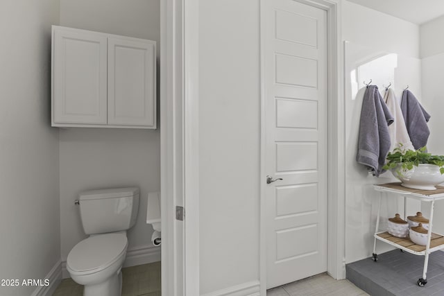 bathroom featuring toilet and baseboards